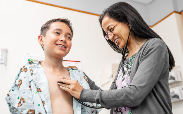 Provider listening to a boy's heart.