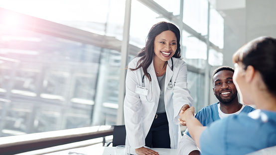 A provider delightfully shaking hands with a woman.