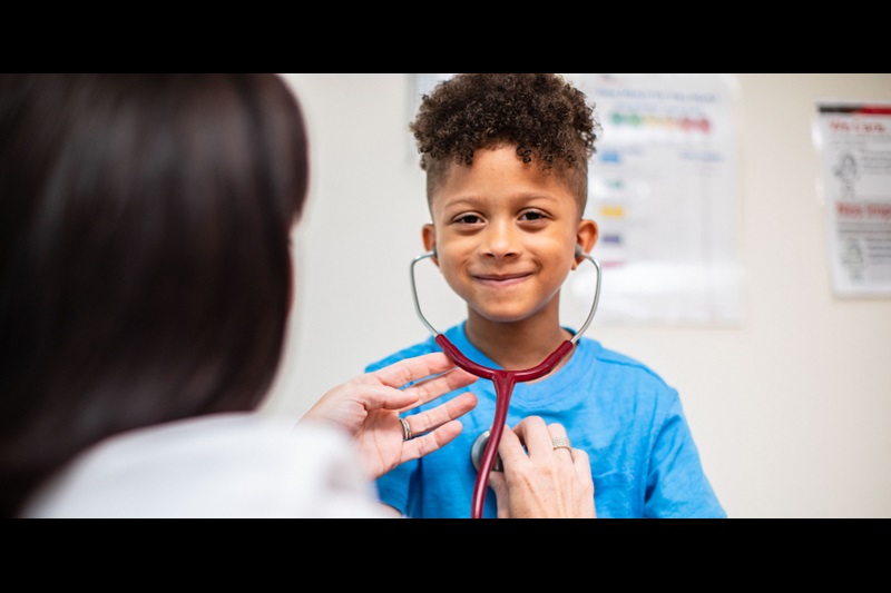 Young Boy Trying Provider's Stethoscope and Listening to His Own Heartbeat.