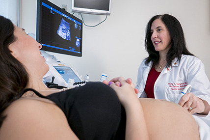 Mujer embarazada siendo examinada por el médico. | Mary Donofrio, M.D., Cardiology, Director of Fetal Heart Program and Amanda Fulgium, Echocardiographer, Cardiology perform a fetal echocardiogram on Fernanda Vessio, Director of Volunteer Services